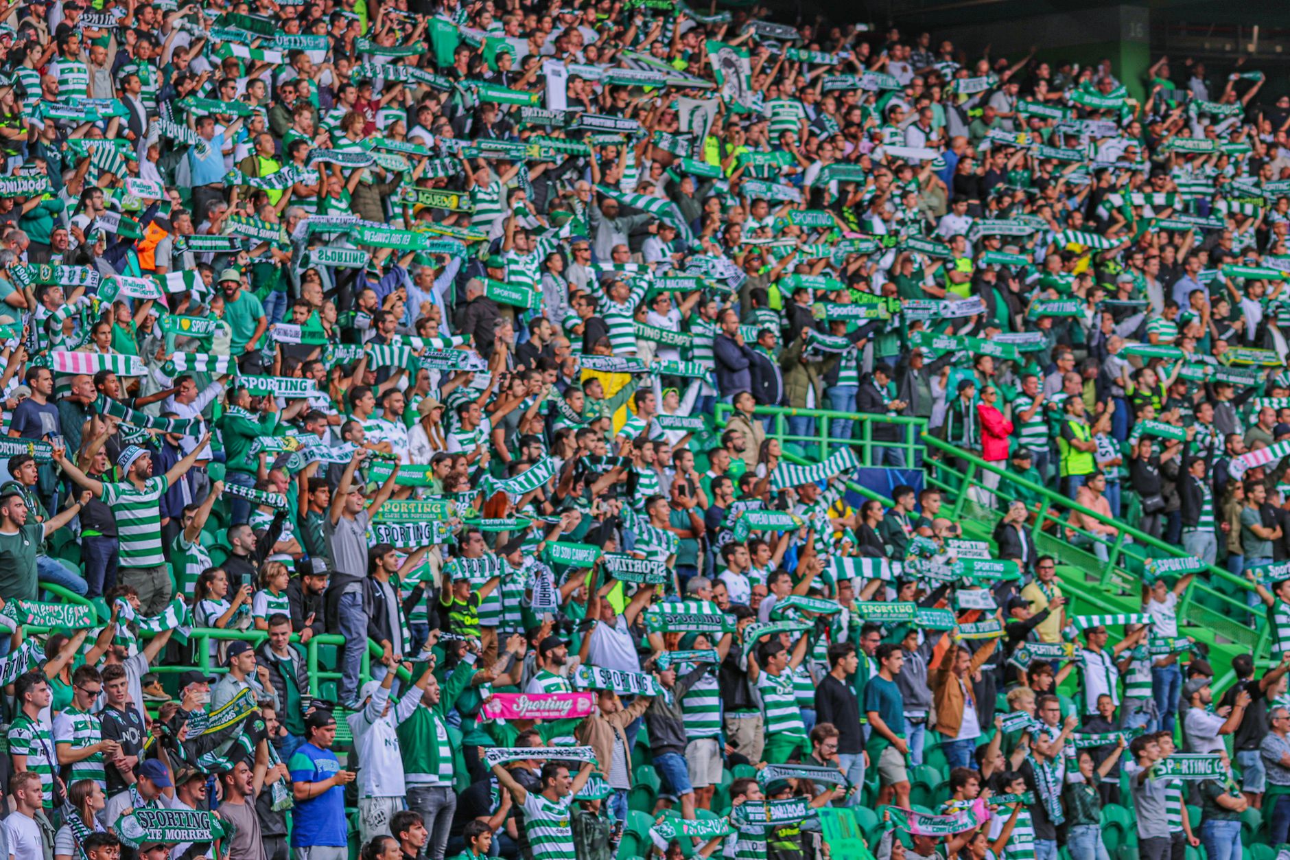 Fans watching a football match on a large screen with a smartphone showing captions and accessibility settings