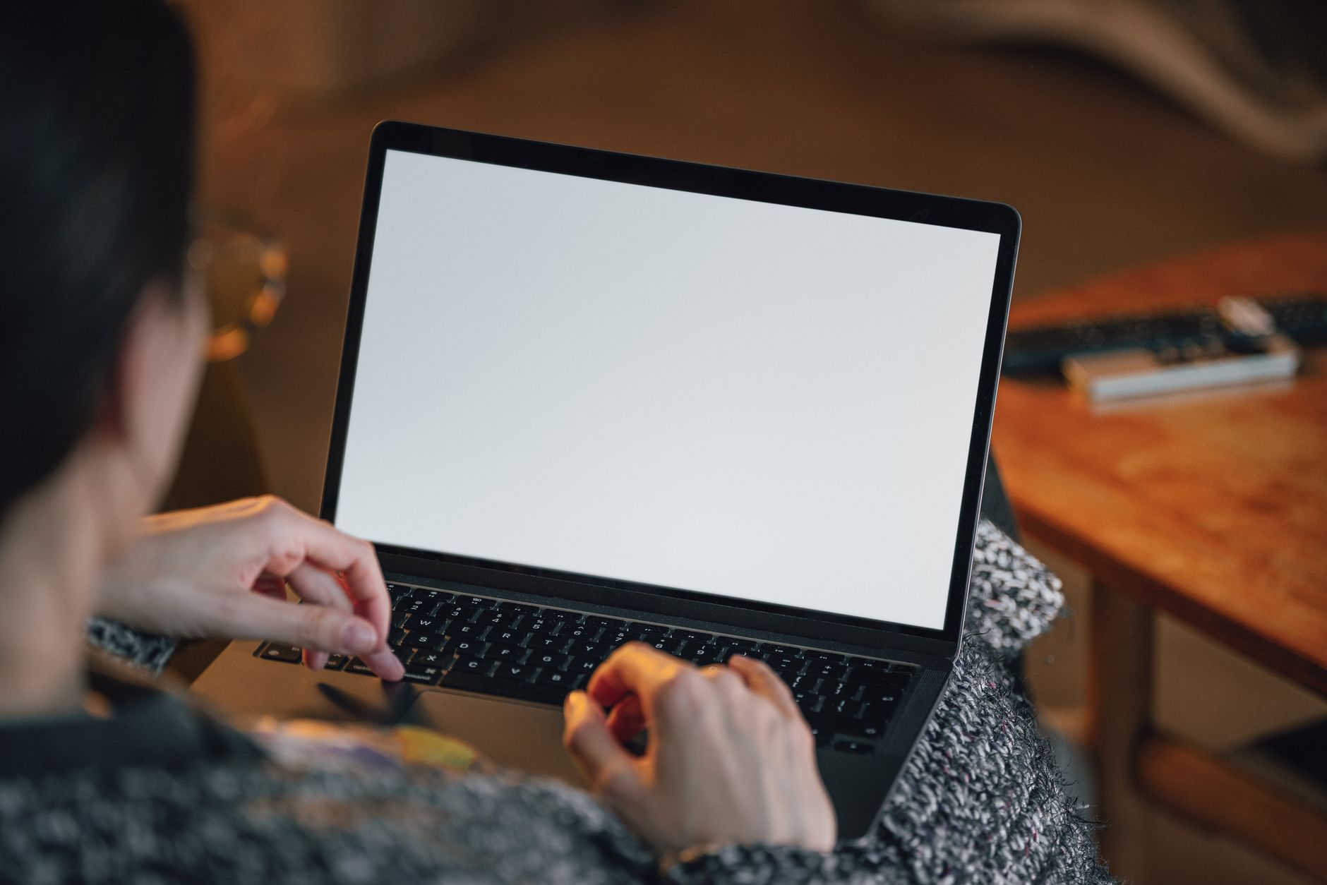 Person taking a break from laptop and phone on a quiet desk with a notebook and a cup of tea