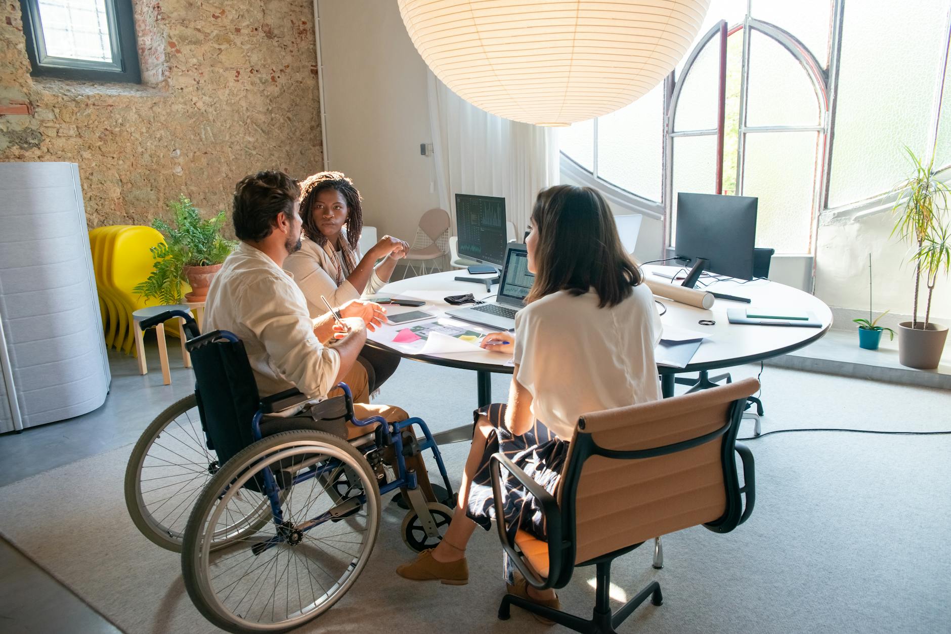 Accessibility compliance team reviewing WCAG checklist on a laptop in an office meeting