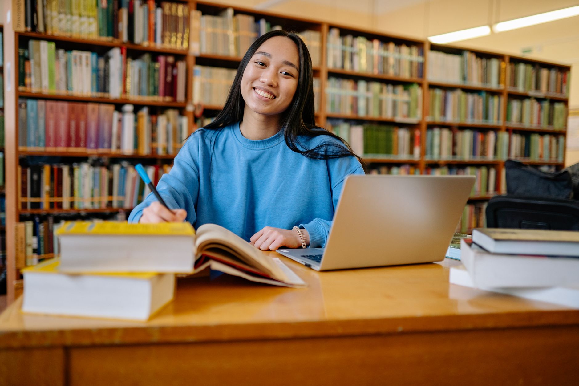 University student using a laptop with accessibility settings enabled in a campus library
