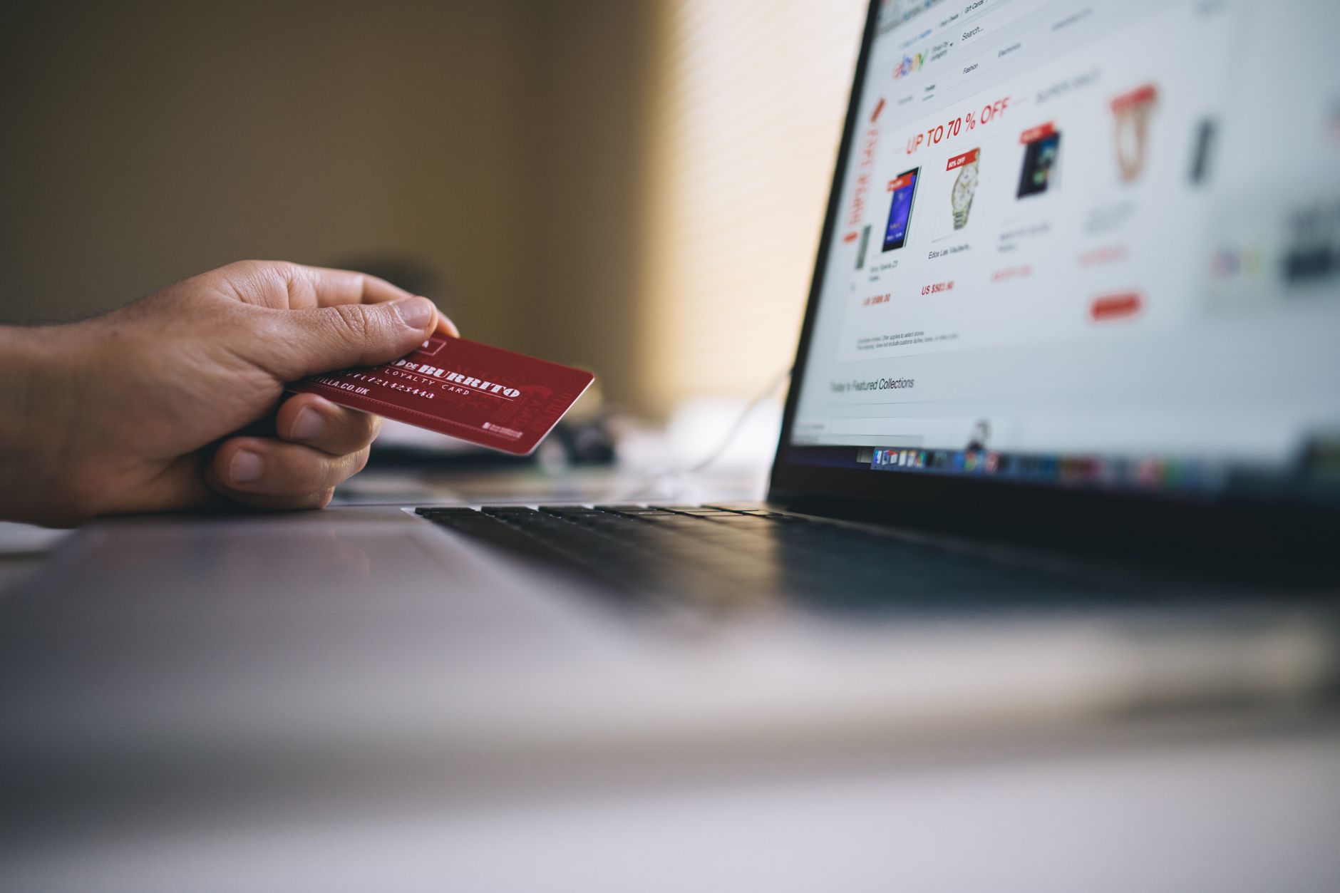 Person using voice search to shop on a smartphone while comparing product results on a laptop