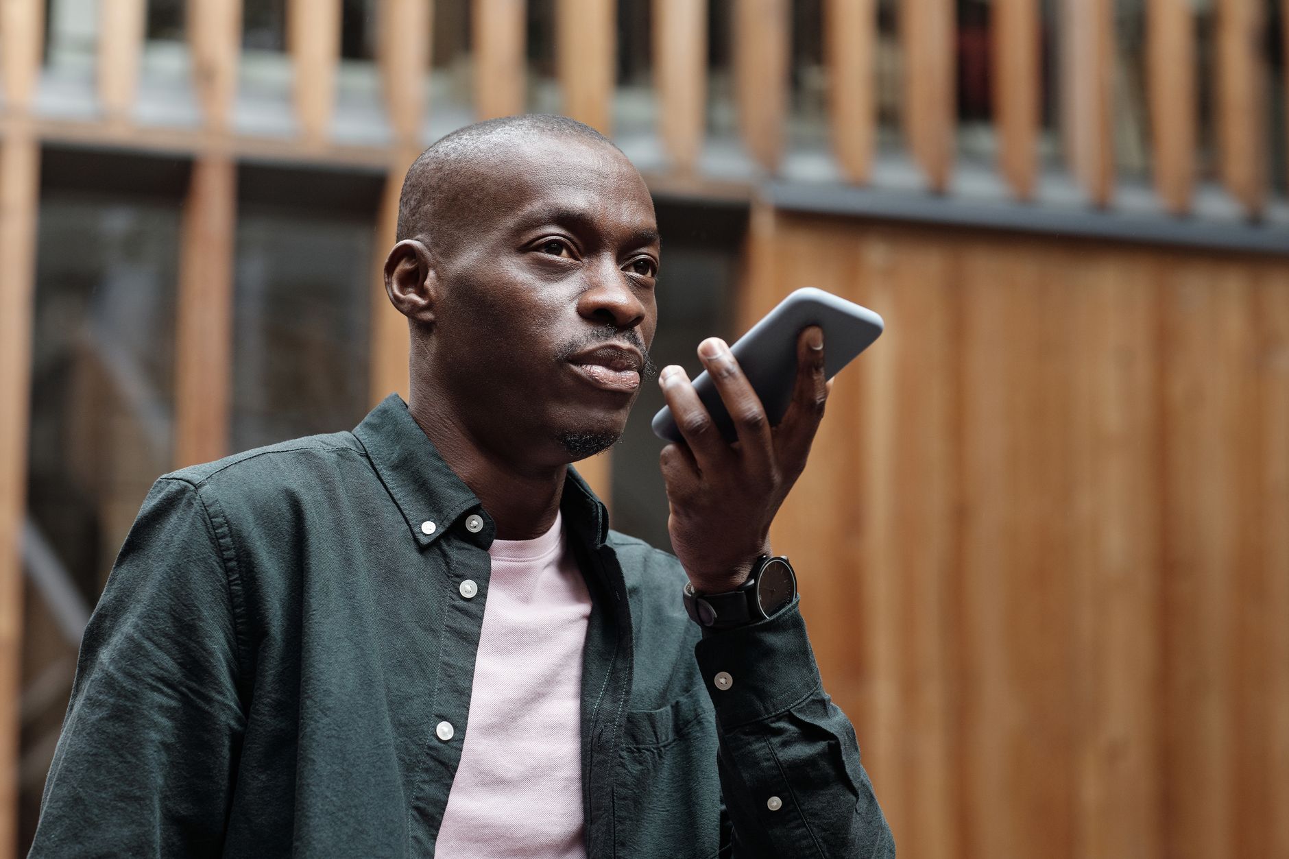 Person using voice search to shop on a smartphone while comparing product results on a laptop