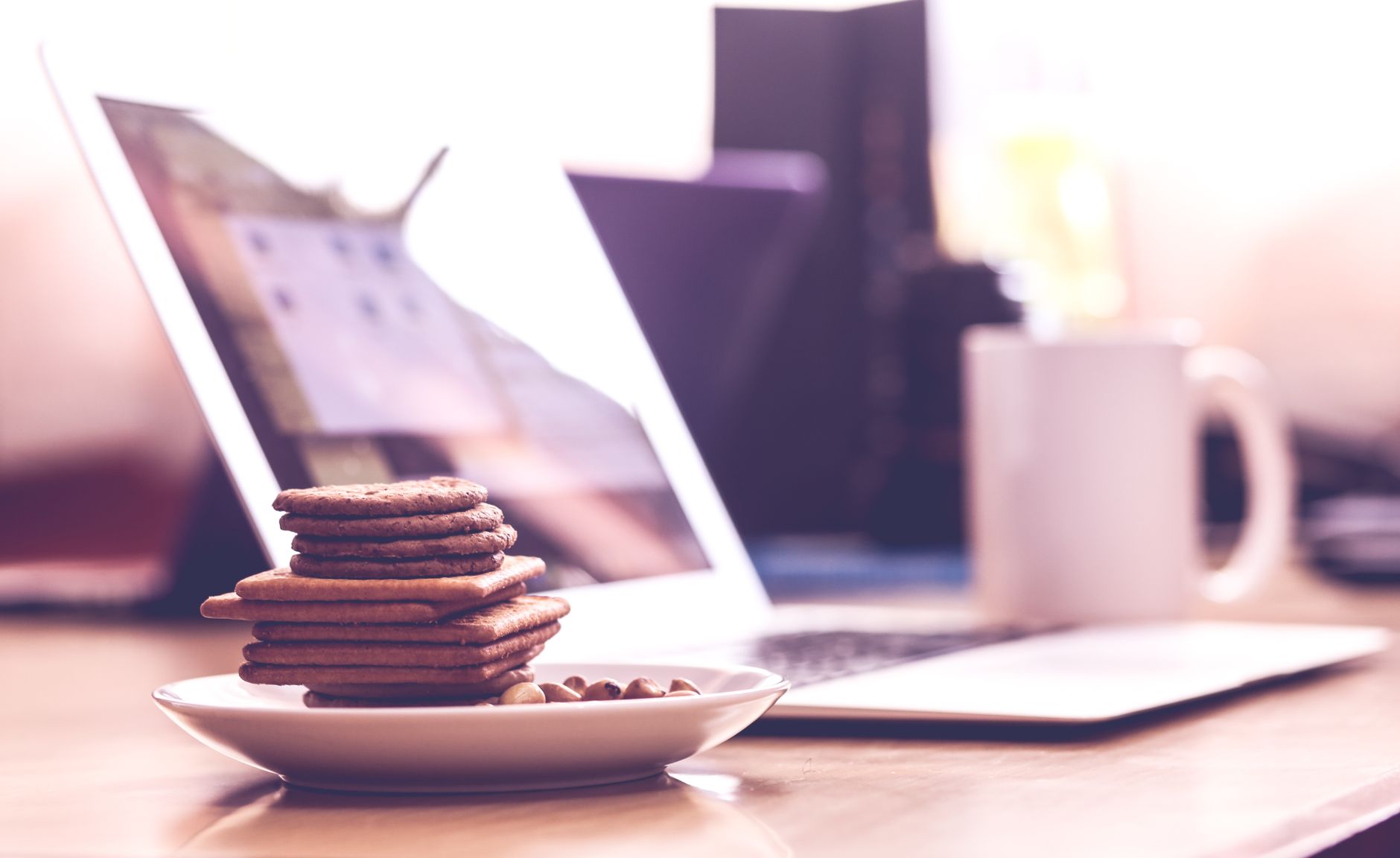 Person reviewing a cookie consent settings panel on a laptop with a checklist document beside it