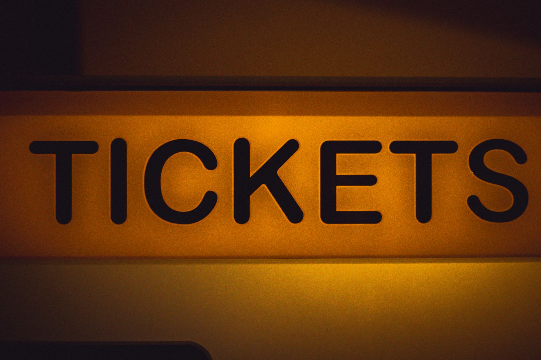 A person using a smartphone movie ticket app with accessibility options visible on screen