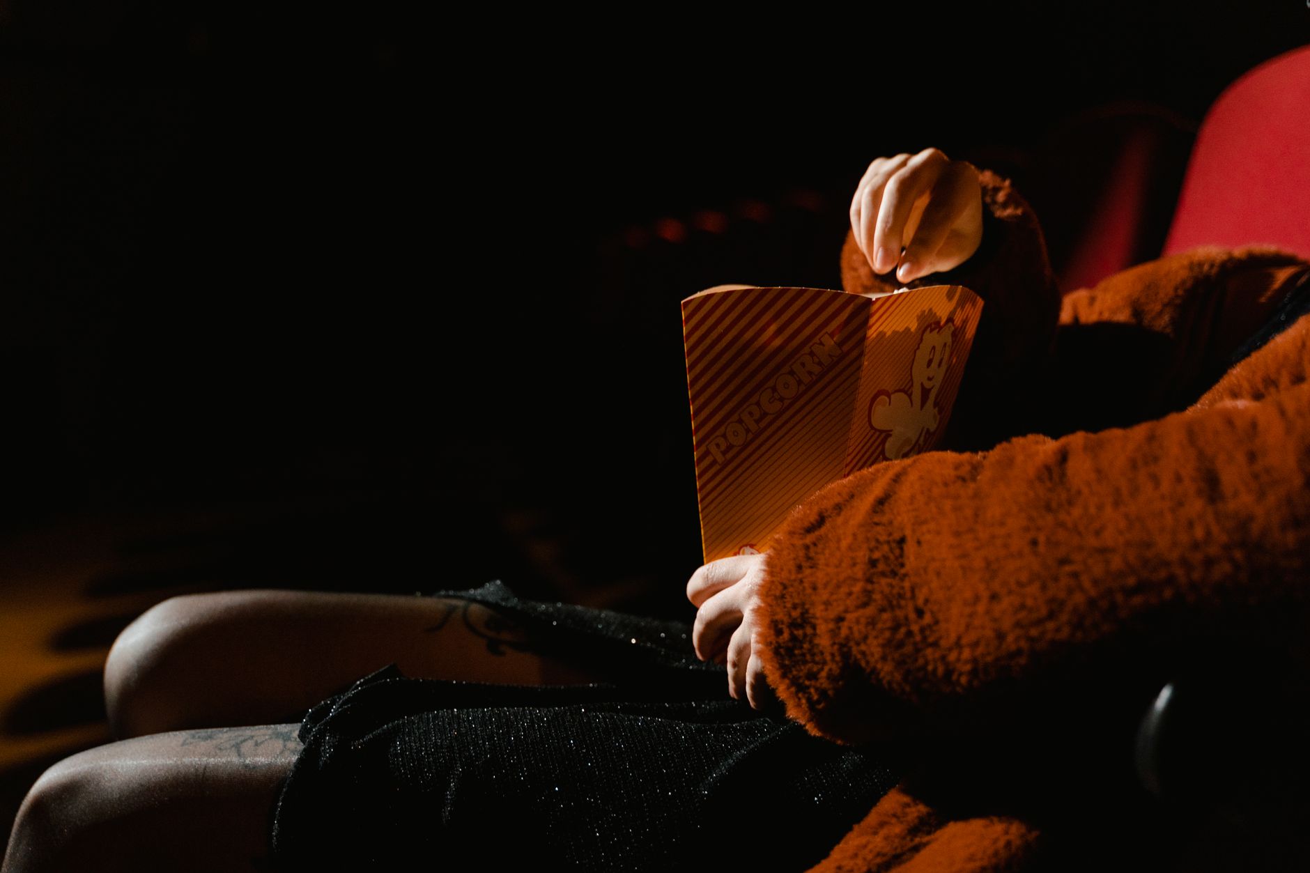 A person using a smartphone movie ticket app with accessibility options visible on screen
