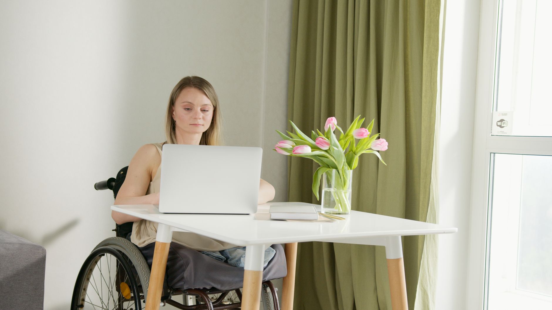 Person using a laptop with accessibility settings open in a modern Romanian office environment