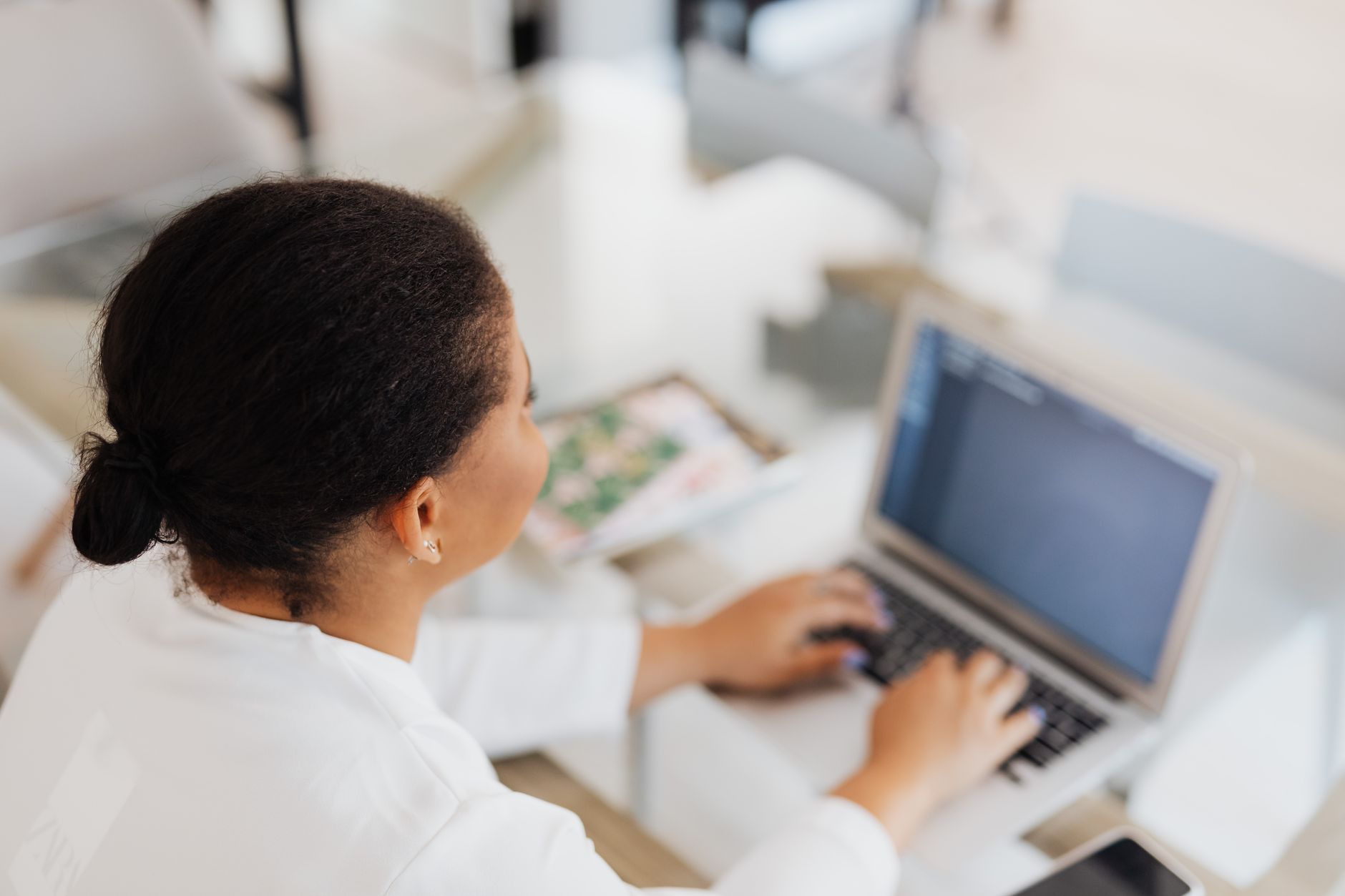 A Rwandan professional using a laptop with accessibility settings visible, representing inclusive digital services