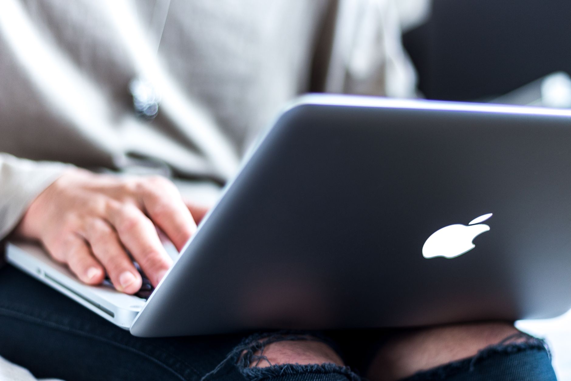 Accessibility specialist reviewing a website on a laptop with a checklist and a screen reader interface visible