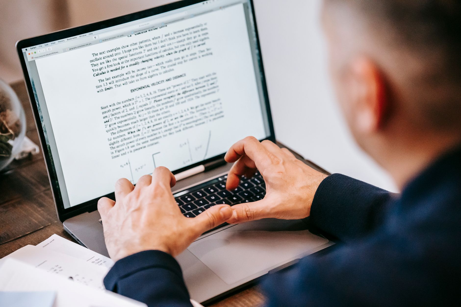 Accessibility specialist reviewing a website on a laptop with a checklist and a screen reader interface visible