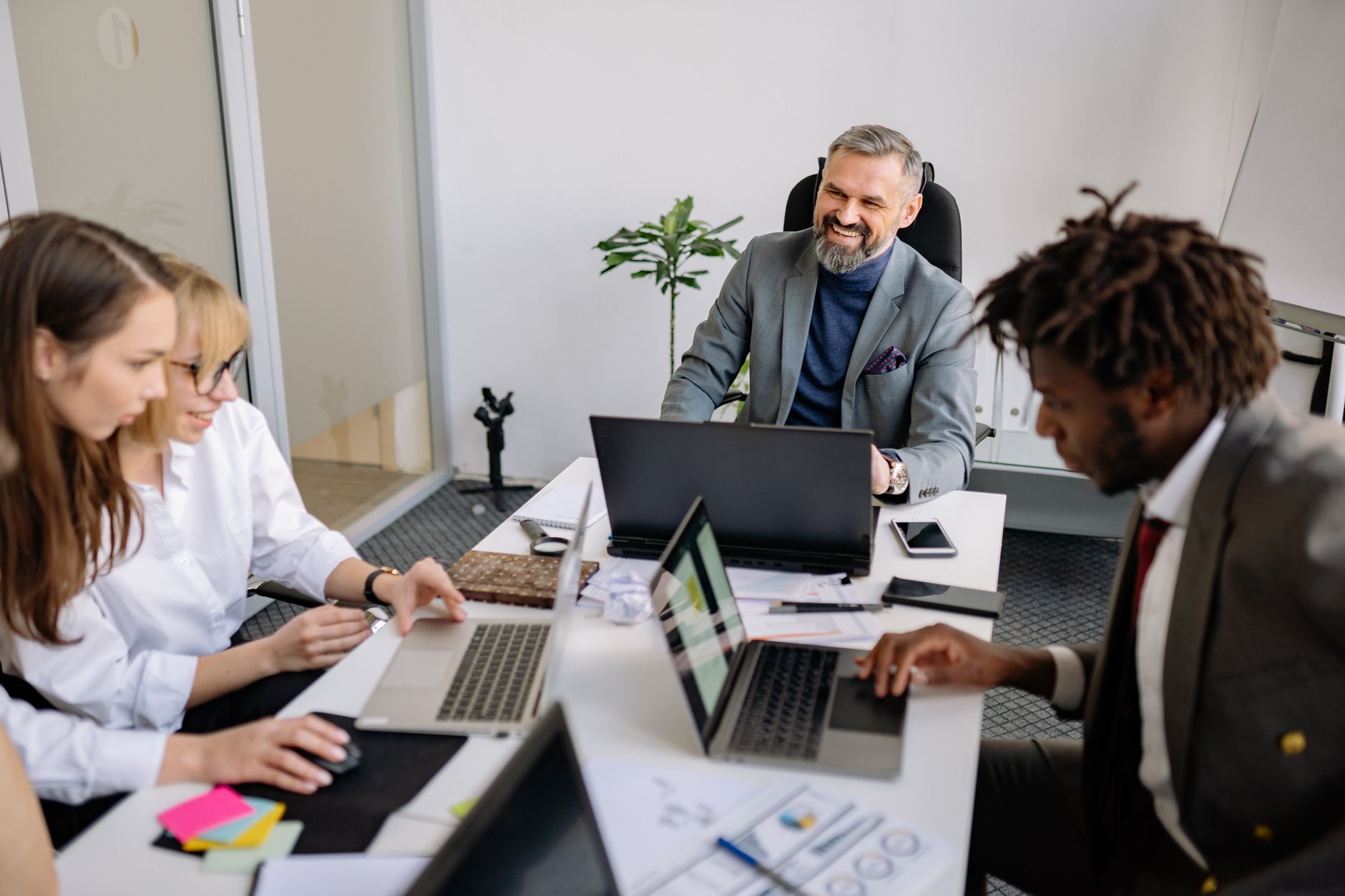Diverse employees collaborating in a modern office with laptops and accessible technology