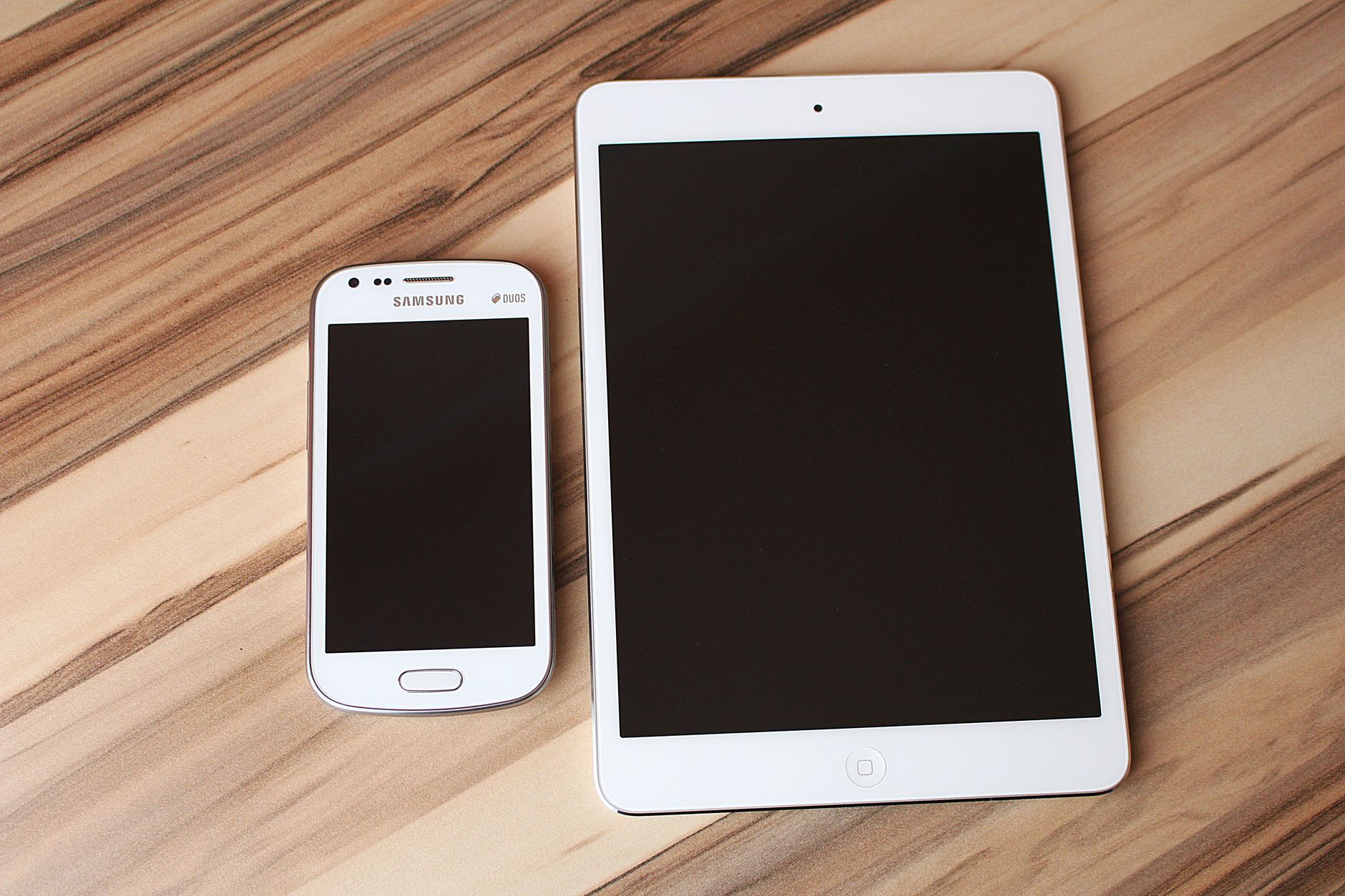 Person comparing prices on an accessible e-commerce website using a laptop and a phone