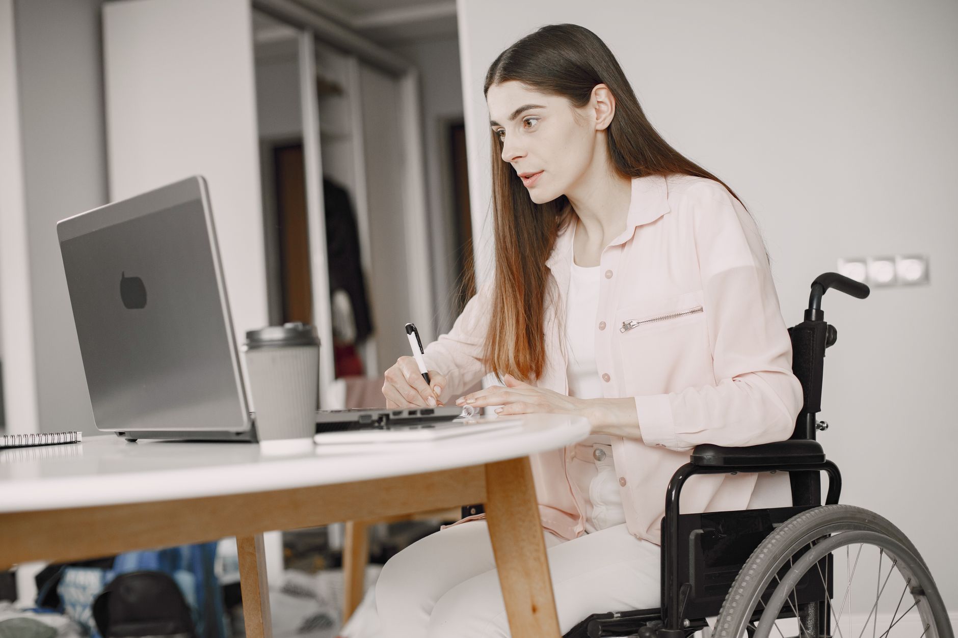 Person comparing prices on an accessible e-commerce website using a laptop and a phone