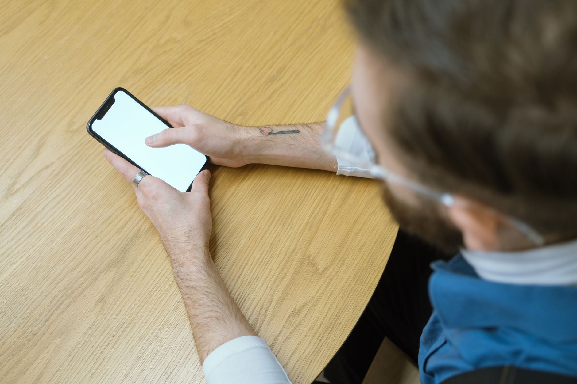 Mobile app developer reviewing accessibility checklist on a smartphone next to a laptop