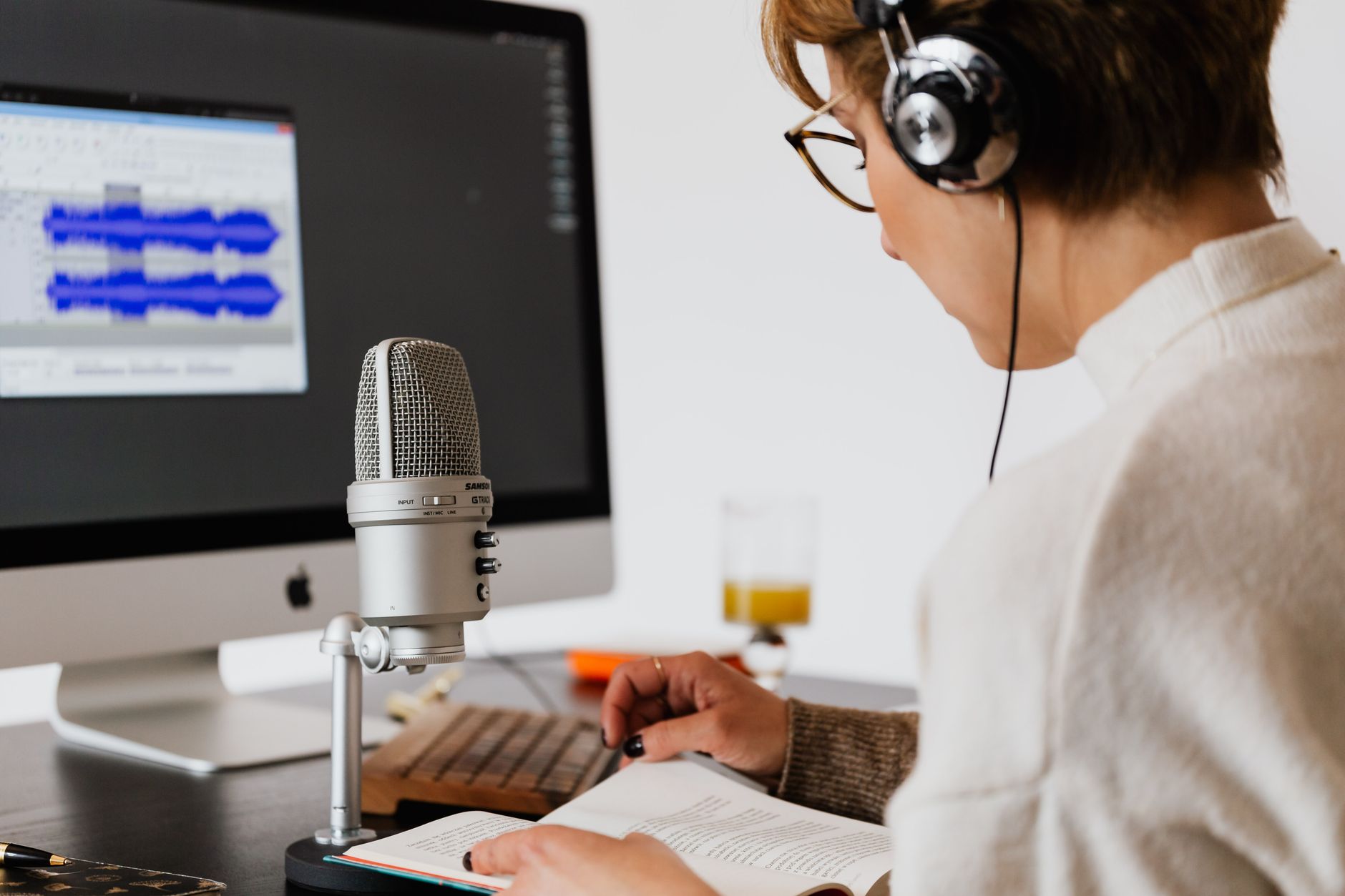 A blind user testing a website on a laptop with a screen reader and headphones while a facilitator takes notes