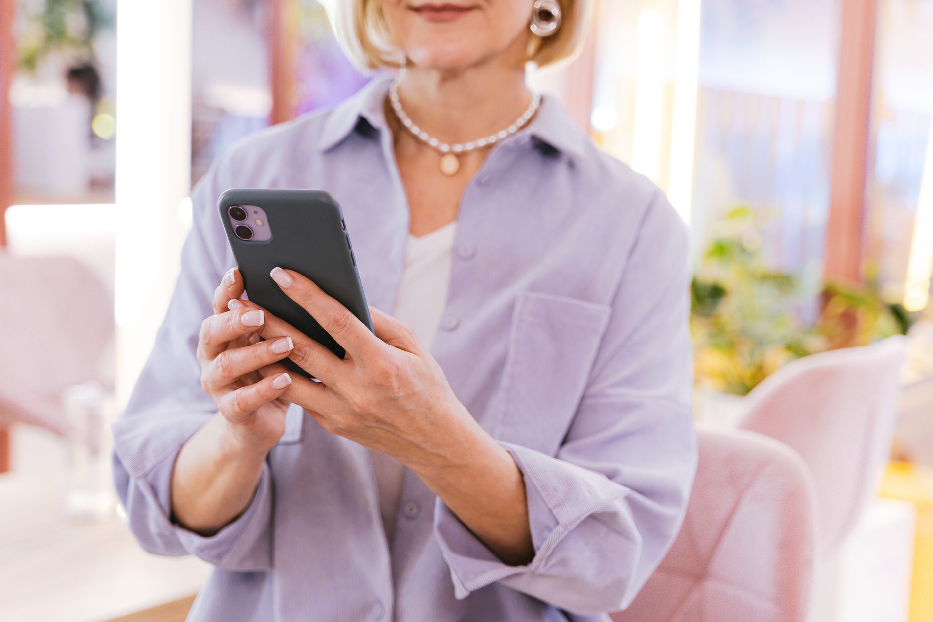 Person checking smartwatch health alert while holding a smartphone with a health app open