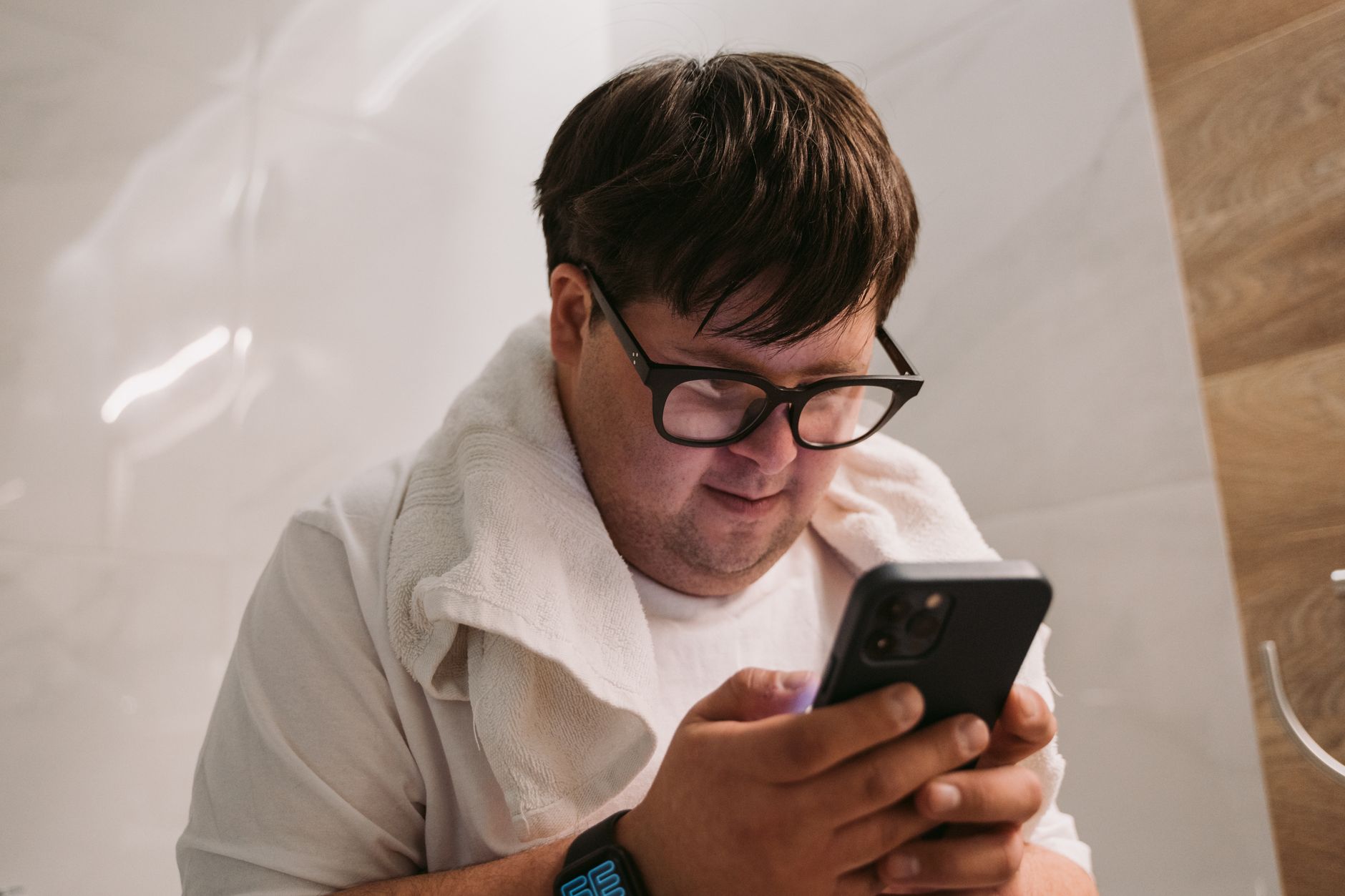 Person checking smartwatch health alert while holding a smartphone with a health app open