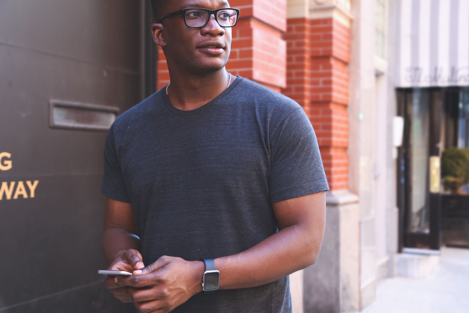 Person checking smartwatch health alert while holding a smartphone with a health app open